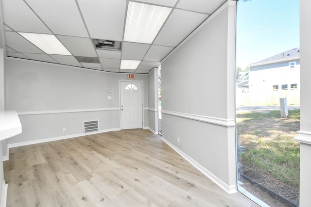 unfurnished room featuring a drop ceiling and light hardwood / wood-style flooring