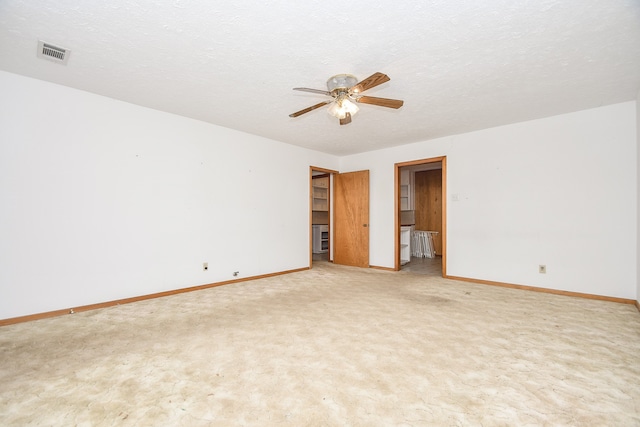 empty room with a textured ceiling, carpet, and ceiling fan