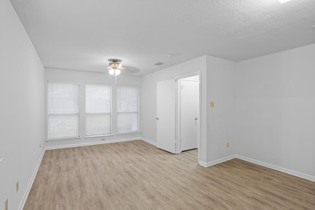 spare room with light hardwood / wood-style floors, a textured ceiling, and ceiling fan