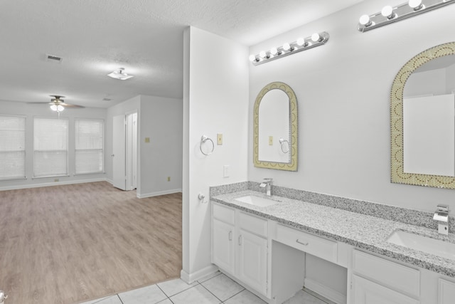 bathroom with vanity, a textured ceiling, hardwood / wood-style flooring, and ceiling fan