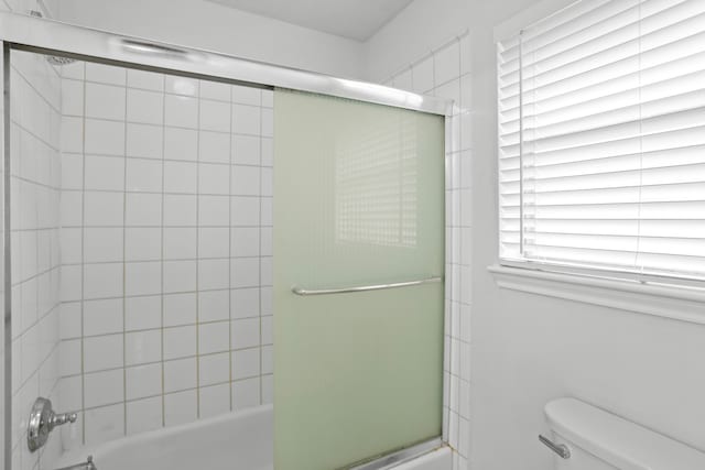 bathroom with toilet and enclosed tub / shower combo