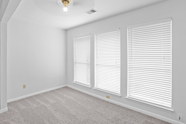 empty room with carpet, plenty of natural light, and ceiling fan