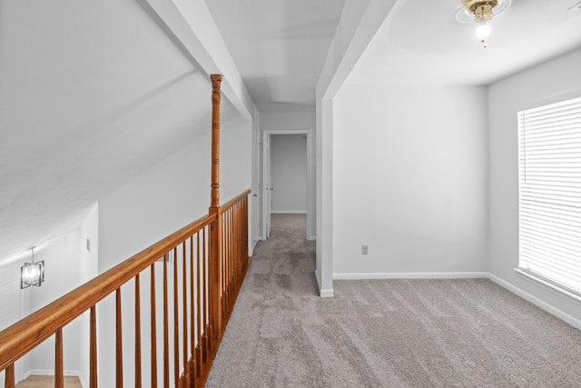 hall with vaulted ceiling and light colored carpet