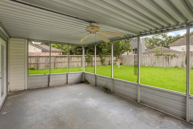 unfurnished sunroom with ceiling fan