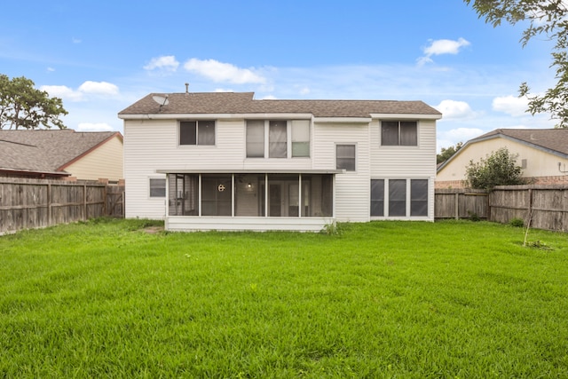 rear view of house featuring a lawn and a sunroom