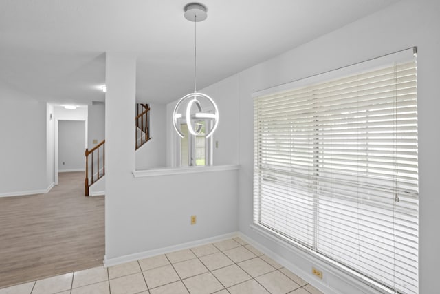 unfurnished dining area featuring light hardwood / wood-style floors and an inviting chandelier