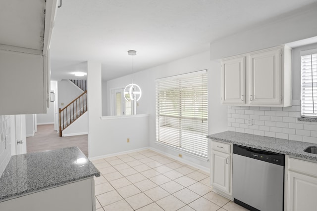 kitchen featuring white cabinets, stainless steel dishwasher, hanging light fixtures, and a wealth of natural light