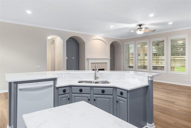 kitchen with sink, light wood-type flooring, an island with sink, stainless steel dishwasher, and gray cabinets