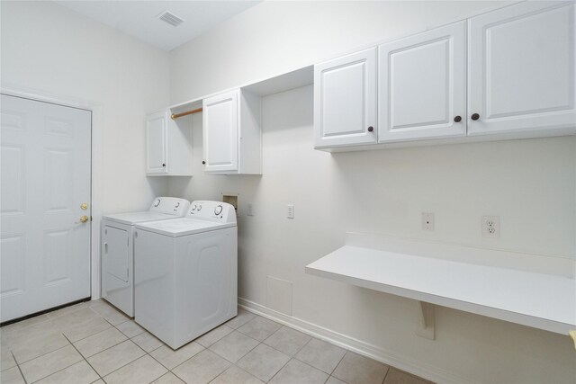 washroom with cabinets, washer and clothes dryer, and light tile patterned floors