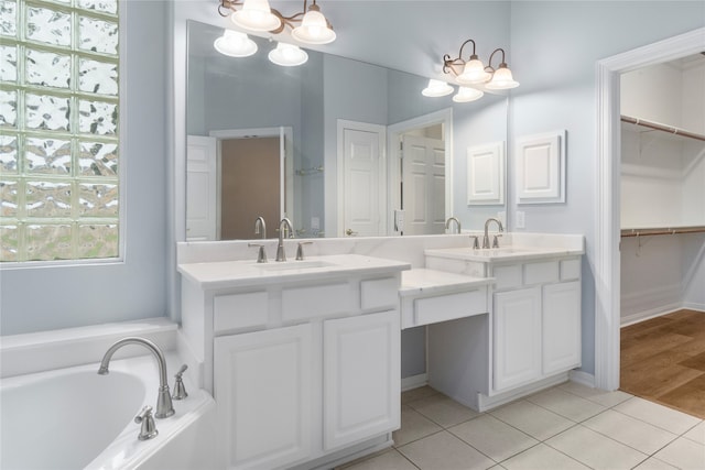 bathroom featuring vanity, a chandelier, a bath, and tile patterned flooring