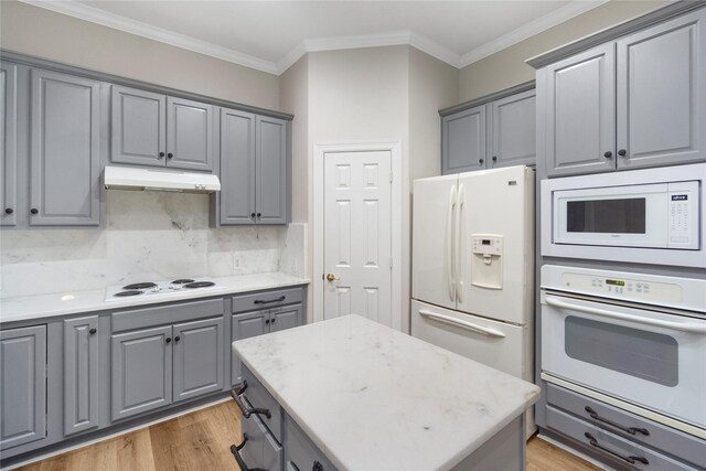 kitchen featuring gray cabinets, light hardwood / wood-style flooring, crown molding, and white appliances