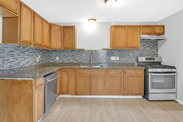 kitchen with decorative backsplash, sink, light wood-type flooring, and stainless steel appliances