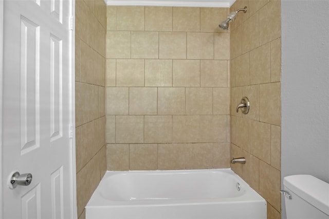 bathroom with tiled shower / bath combo and toilet