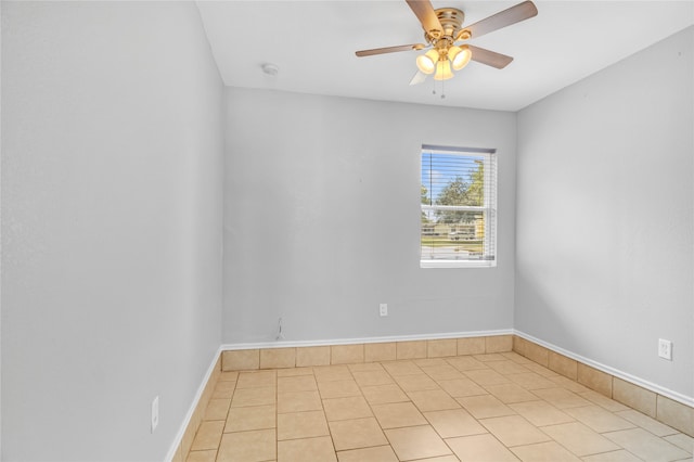 empty room with ceiling fan and light tile patterned floors