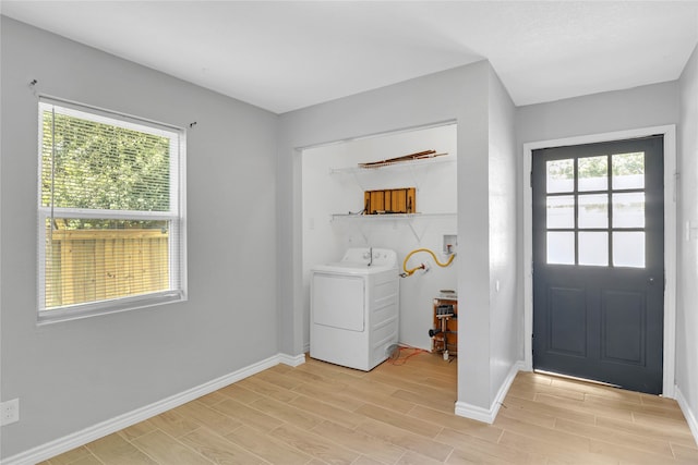 laundry area featuring washer / dryer, light hardwood / wood-style floors, and plenty of natural light