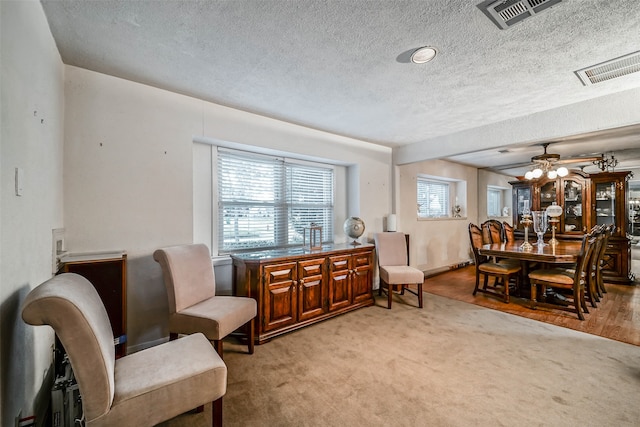 sitting room featuring light carpet, a textured ceiling, and ceiling fan