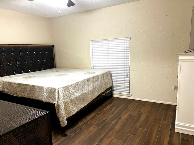 bedroom featuring dark wood-type flooring, ceiling fan, and a textured ceiling