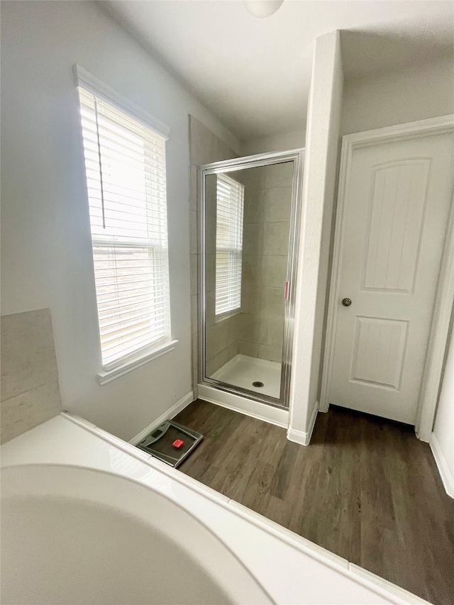 bathroom featuring hardwood / wood-style flooring and walk in shower