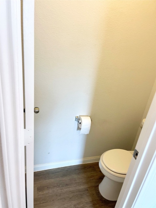 bathroom with toilet and hardwood / wood-style floors