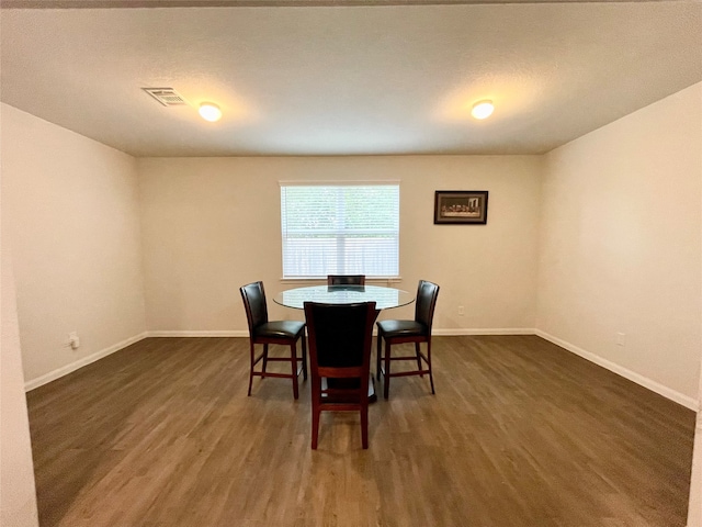 dining area featuring a textured ceiling and dark hardwood / wood-style flooring