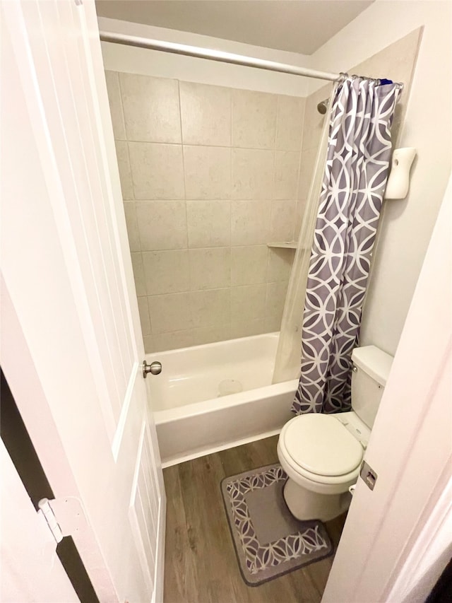 bathroom with shower / bath combo, wood-type flooring, and toilet