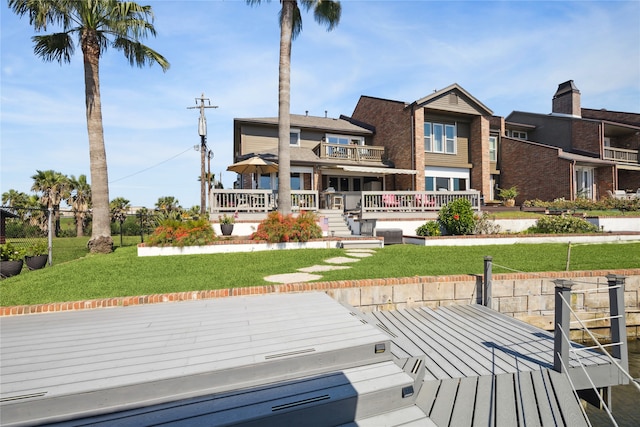 rear view of property featuring a yard and a deck