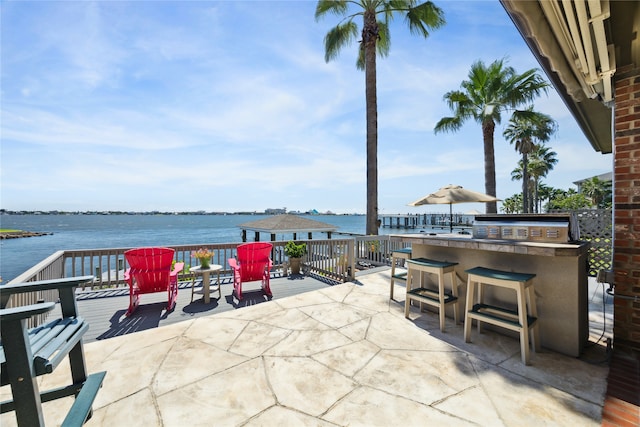 view of patio featuring exterior bar and a water view