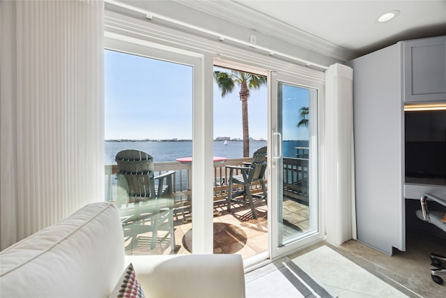 doorway with ornamental molding and a water view