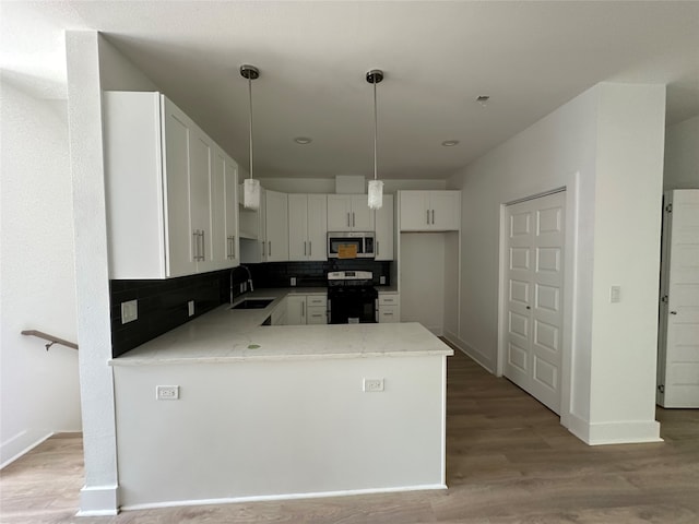 kitchen with backsplash, white cabinetry, light hardwood / wood-style flooring, black electric range, and sink