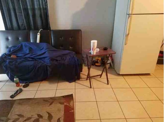 tiled bedroom with white fridge