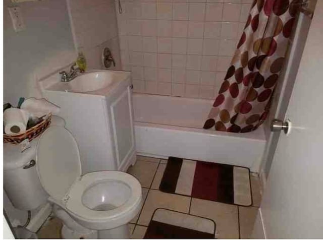 full bathroom featuring toilet, shower / bath combo, vanity, and tile patterned flooring