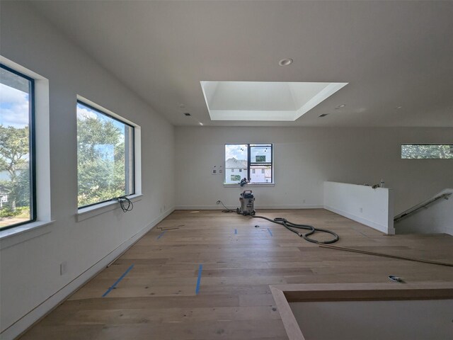 empty room featuring light hardwood / wood-style floors and a skylight