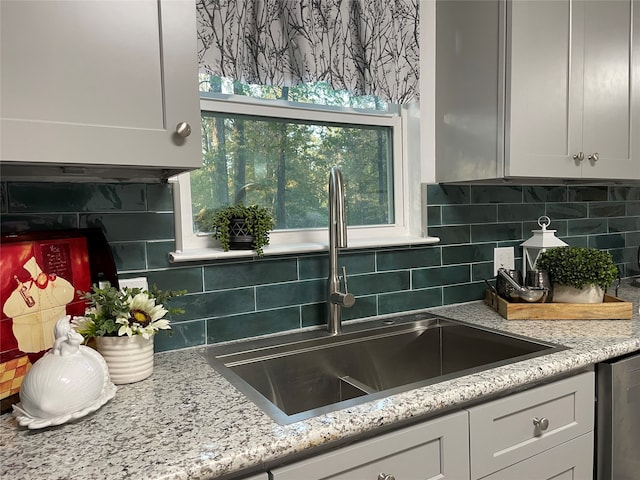 kitchen with white cabinetry, tasteful backsplash, sink, and dishwasher