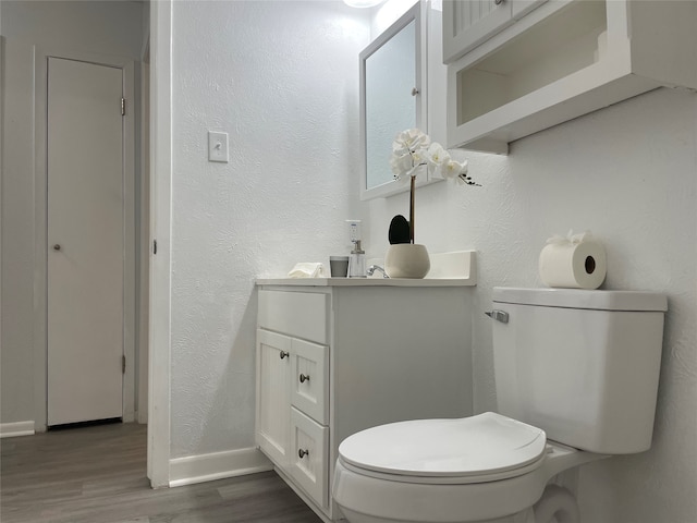 bathroom featuring toilet, hardwood / wood-style floors, and vanity