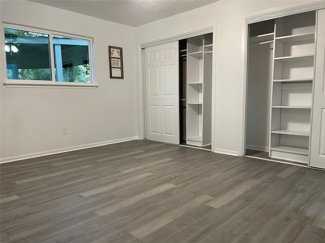 unfurnished bedroom featuring a textured ceiling and dark hardwood / wood-style flooring