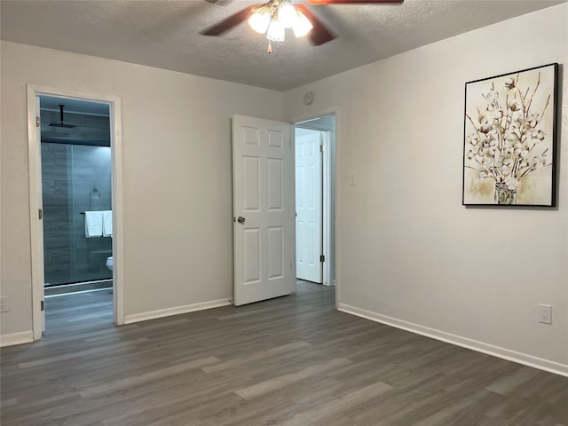 unfurnished bedroom featuring dark hardwood / wood-style flooring, a textured ceiling, ensuite bath, and ceiling fan