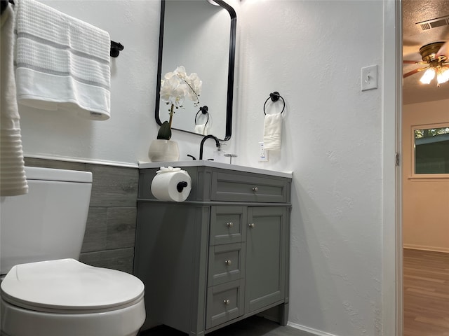 bathroom with vanity, hardwood / wood-style flooring, toilet, and tile walls