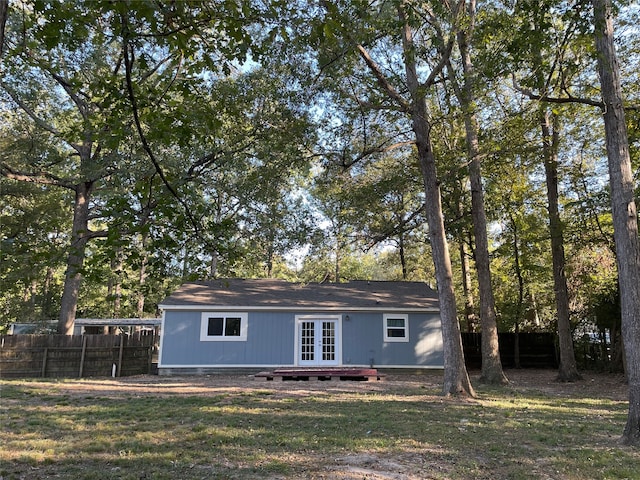 back of house with french doors and a yard