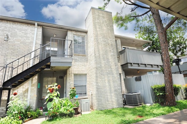 rear view of property with central AC and a balcony