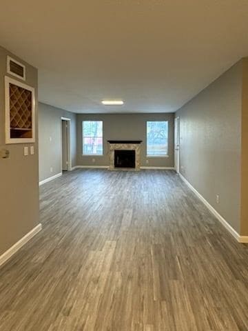 9700 Leawood Blvd Unit 2110, Houston, TX 77099 - unfurnished living room featuring baseboards, wood finished floors, and a fireplace