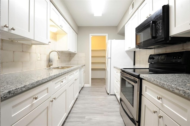 9700 Leawood Blvd Unit 2110, Houston, TX 77099 - kitchen with stainless steel electric stove, black microwave, a sink, white cabinetry, and tasteful backsplash