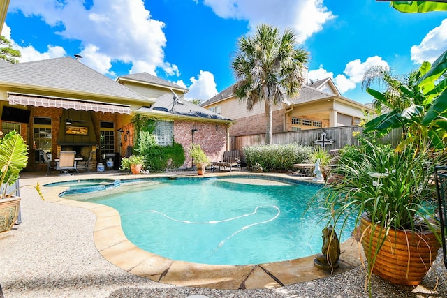 view of swimming pool with a pool with connected hot tub, fence, and a patio