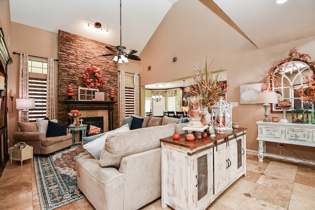 living room with visible vents, a fireplace, high vaulted ceiling, and ceiling fan with notable chandelier