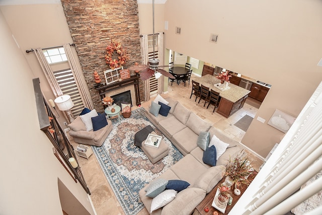 living room featuring a large fireplace, visible vents, and a towering ceiling