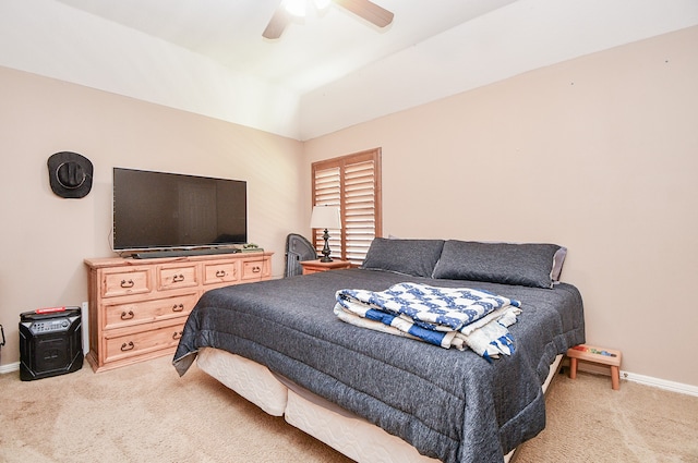 bedroom with light carpet, lofted ceiling, a ceiling fan, and baseboards