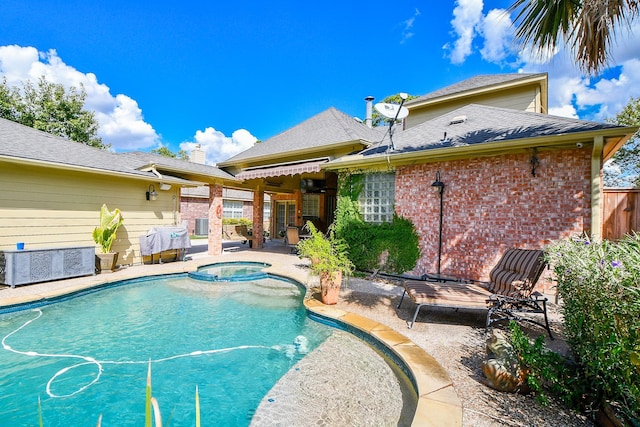 view of swimming pool with a pool with connected hot tub, a patio area, fence, and area for grilling