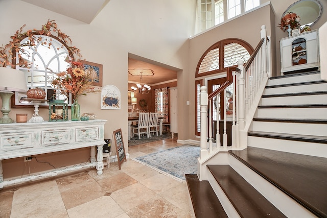 foyer with an inviting chandelier, baseboards, stairs, and a high ceiling