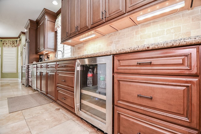 kitchen with light tile patterned floors, decorative backsplash, wine cooler, light stone countertops, and crown molding