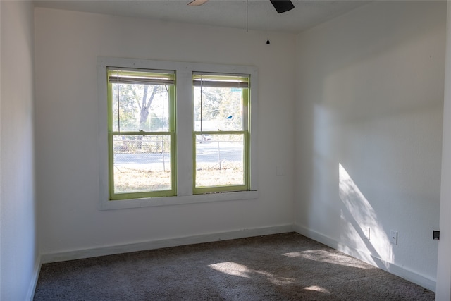 unfurnished room featuring dark colored carpet and ceiling fan