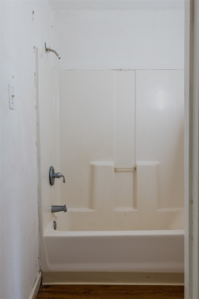 bathroom with wood-type flooring and shower / washtub combination